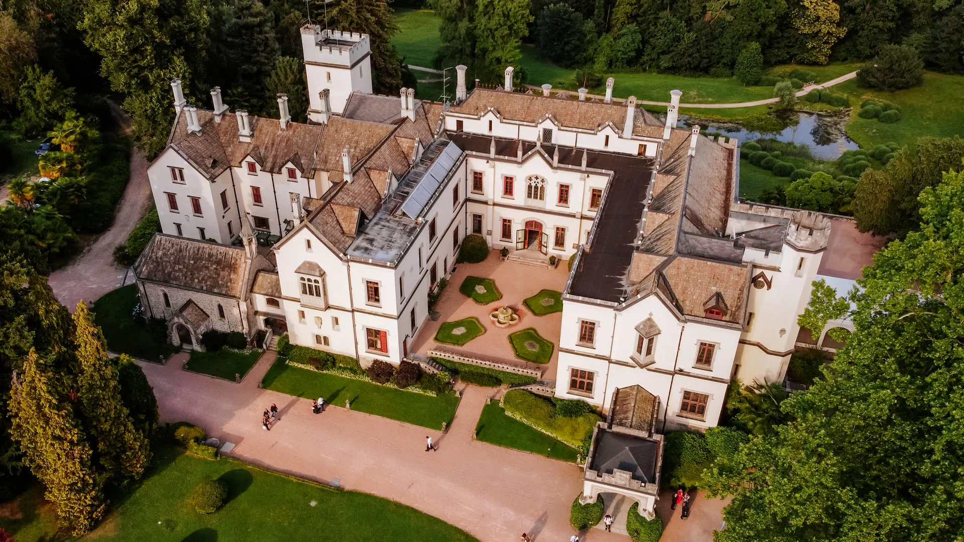 Neo-Gothic castle with turrets and formal gardens, seen from above