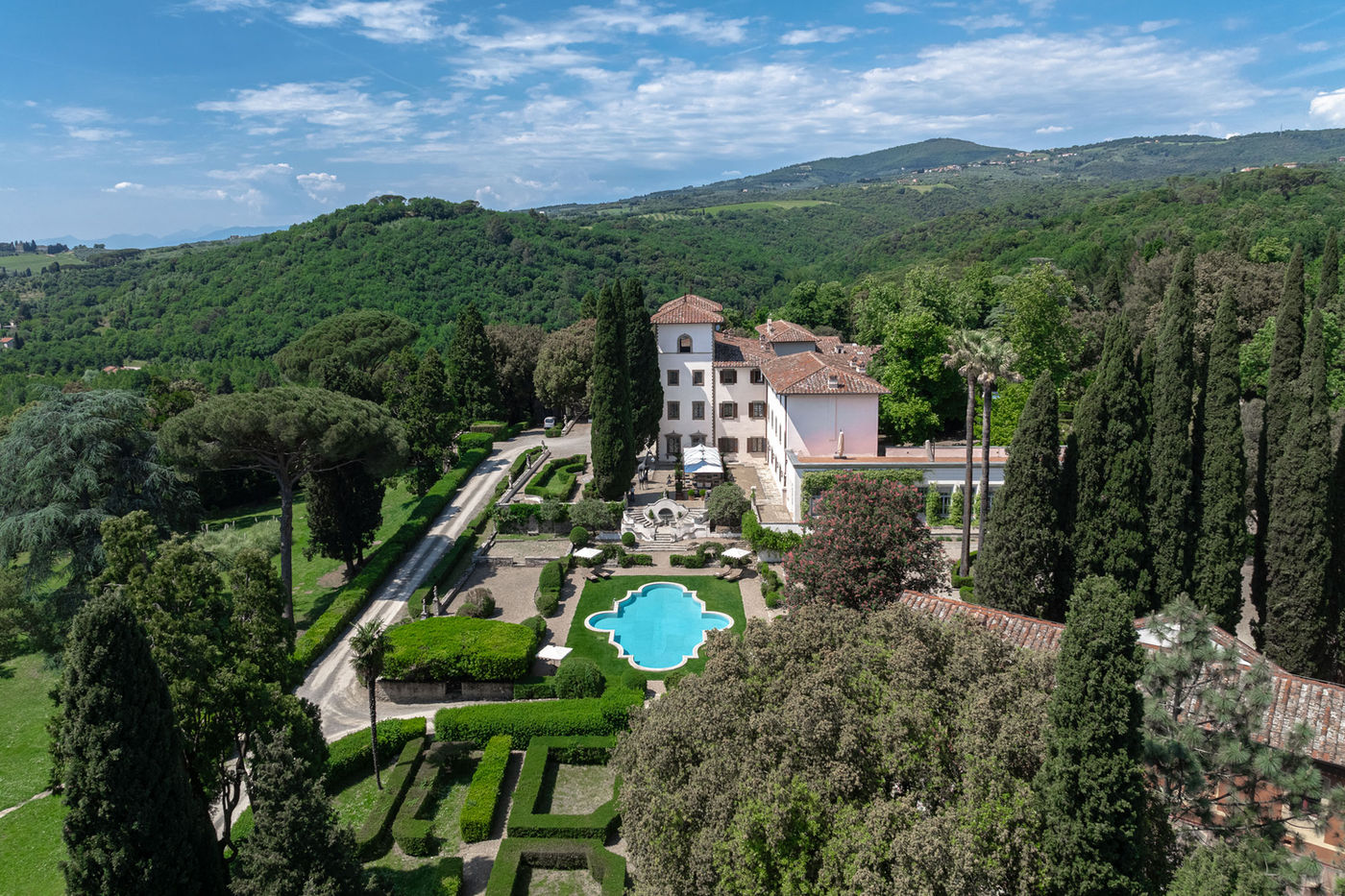 Tuscany hillside villa surrounded by cypress trees and gardens